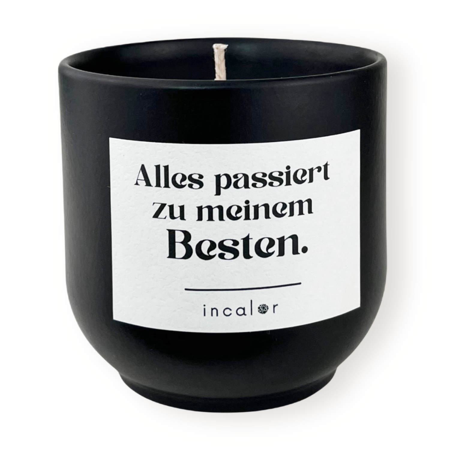 Freigestellte Kerze aus dunkler Keramik (Farbton basalt) mit Etikett der Affirmation "Alles passiert zu meinem Besten." – stilvolle Designkerze von incalor für Achtsamkeit, Selbstmotivation und modernes Interior.