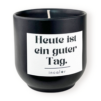 Freigestellte Kerze aus dunkler Keramik (Farbton Basalt) mit Etikett der Affirmation "Heute ist ein guter Tag." – stilvolle Designkerze von incalor für Achtsamkeit, Selbstmotivation und modernes Interior.