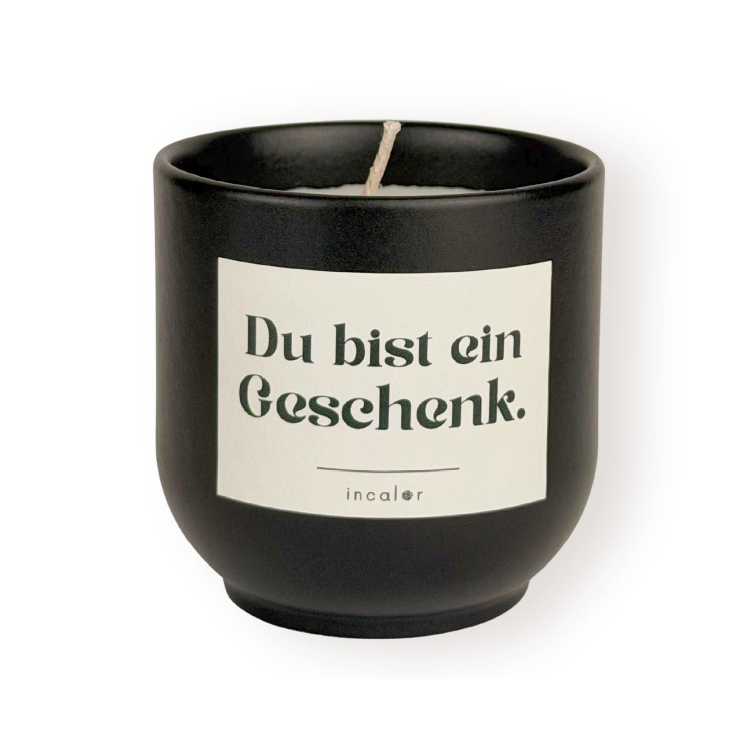 Schwarze (basalt) Duftkerze mit weißem Etikett und der Aufschrift „Du bist ein Geschenk.“ sowie dem Markennamen „incalor“ darunter; freigestellt vor weißem Hintergrund