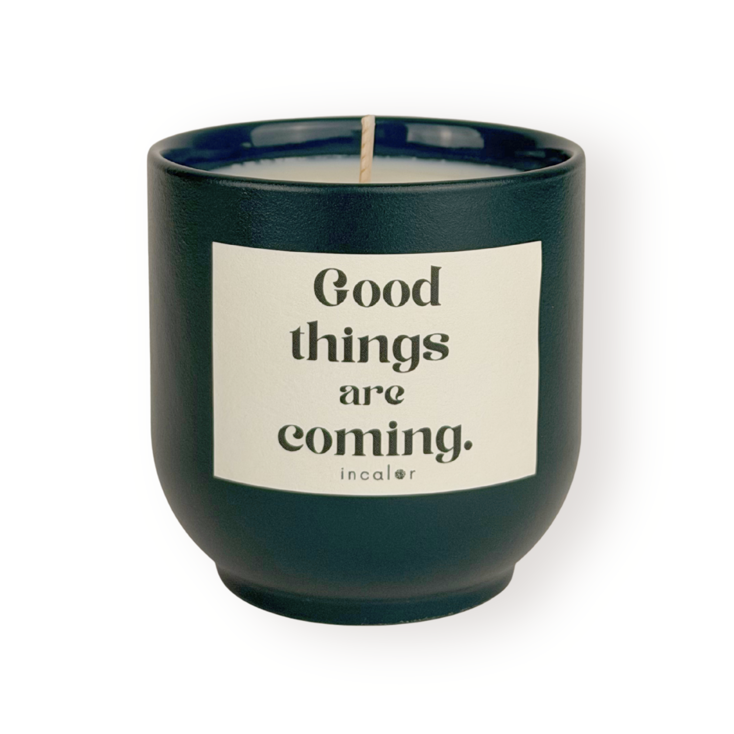 Dunkelgrüne Duftkerze (deep ivy) mit beigem Etikett vor weißem Hintergrund. Auf dem Etikett steht in schwarzer Schrift: "Good things are coming." Darunter befindet sich das Markenlogo "incalor". Die Kerze ist zentral ausgerichtet und gleichmäßig beleuchtet.