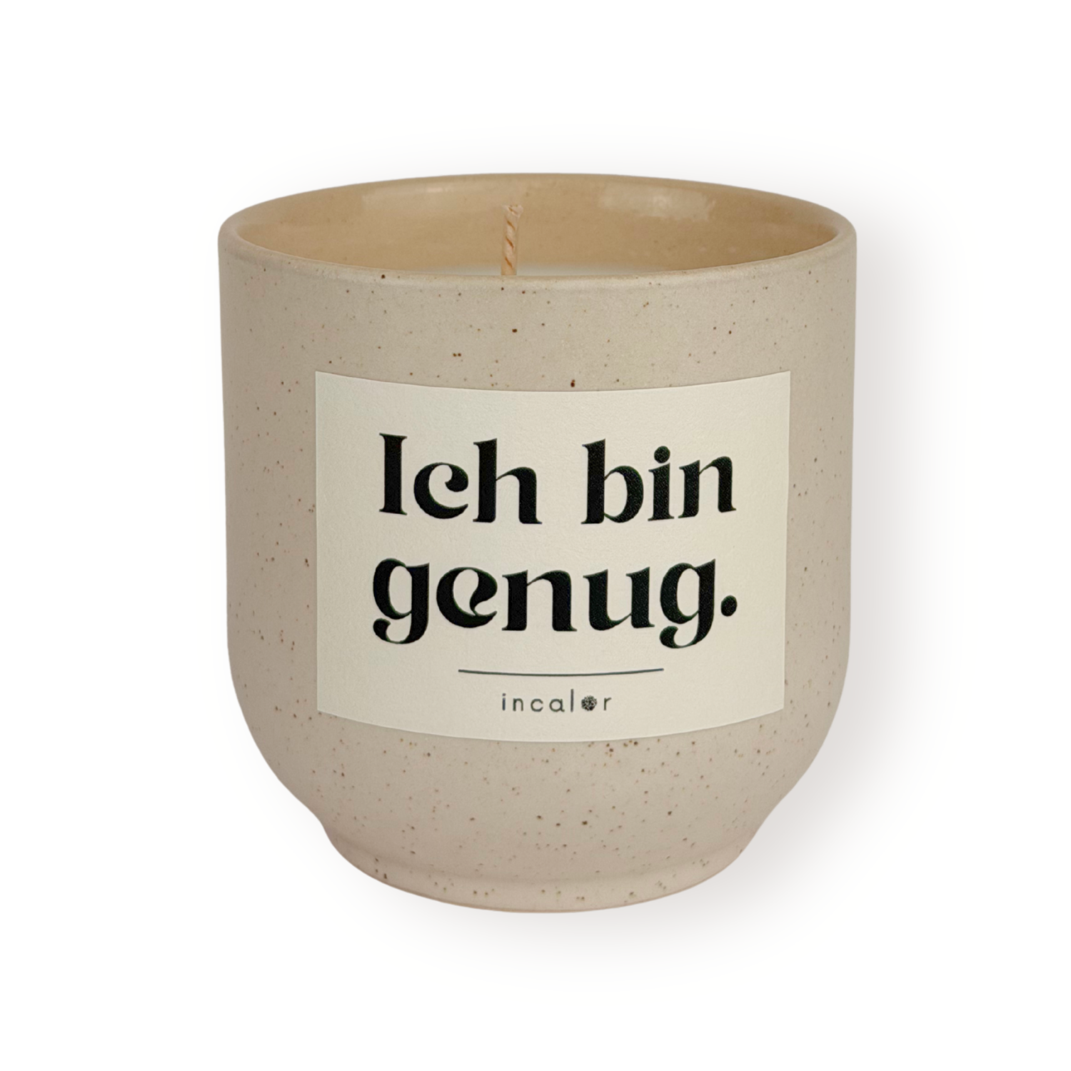 Beige Duftkerze (sahara) mit dezent gesprenkelter Oberfläche und weißem Etikett mit der Aufschrift „Ich bin genug.“ von incalor, freigestellt vor weißem Hintergrund 