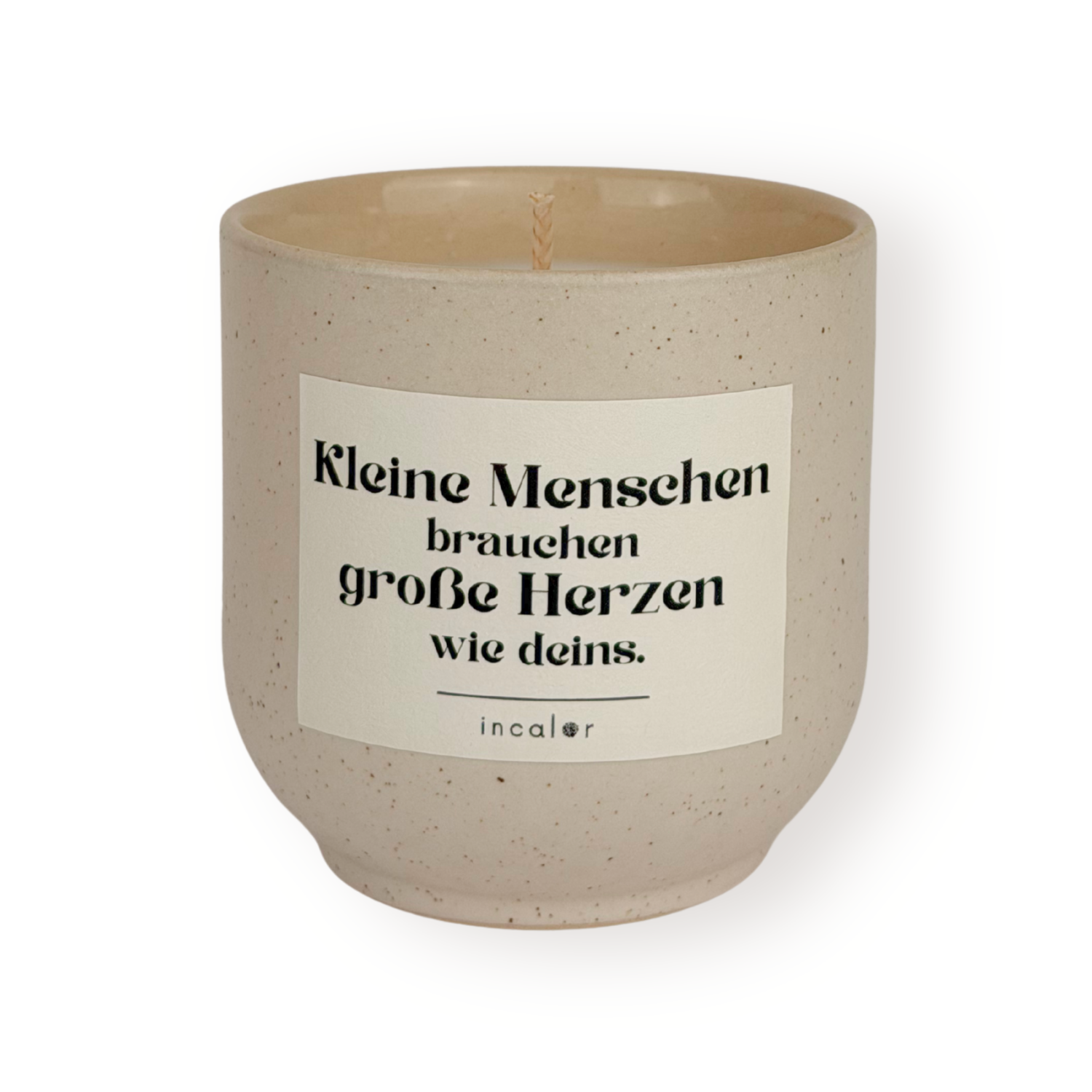 Beige Duftkerze (sahara) mit dezent gesprenkelter Oberfläche und weißem Etikett mit der Aufschrift „Kleine Menschen brauchen große Herzen wie deins.“ von incalor, freigestellt vor weißem Hintergrund 
