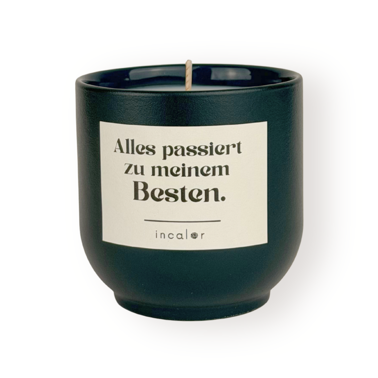 Dunkelgrüne Duftkerze (deep ivy) mit beigem Etikett vor weißem Hintergrund. Auf dem Etikett steht in schwarzer Schrift: "Alles passiert zu meinem Besten." Darunter befindet sich das Markenlogo "incalor". Die Kerze ist mittig platziert und klar ausgeleuchtet.