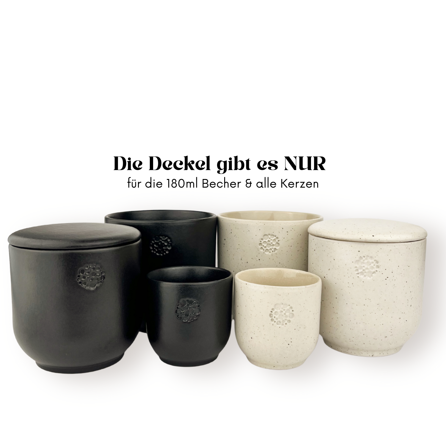 Mehrere Keramikbecher und Kerzengläser in Schwarz (basalt) und Creme (sahara) stehen nebeneinander; zwei der größeren Gefäße sind mit passenden Deckeln versehen. Über den Gefäßen steht der Text: „Die Deckel gibt es NUR für die 180ml Becher & alle Kerzen“.